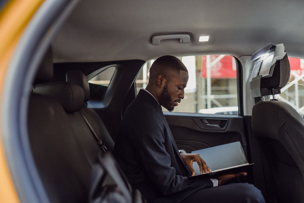 Hombre revisando documentos del seguro todo riesgo Equidad Seguros dentro del carro